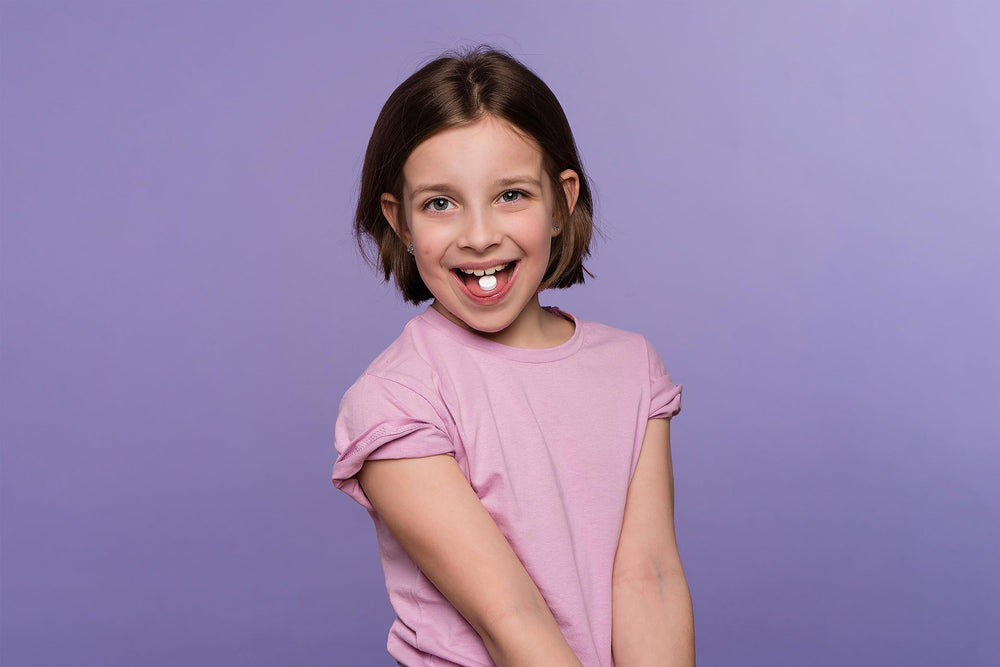 Child taking a ProBiora Kids orange chewable probiotic tablet