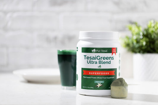 One scoop of Pur Tesai TesaiGreens powder being added to a glass of water