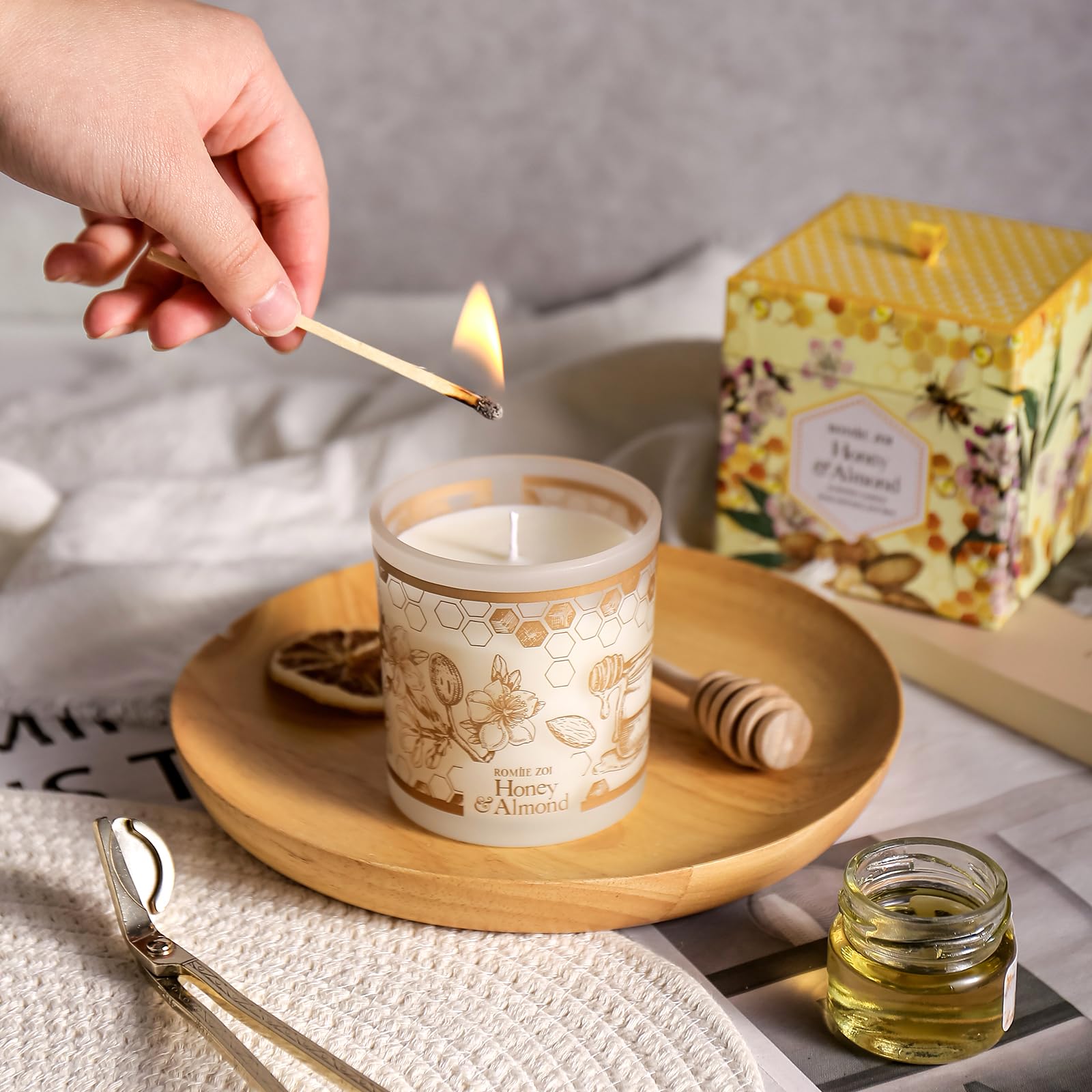 ROMIIE ZOI Honey & Almond candle packaging and bottle on a table