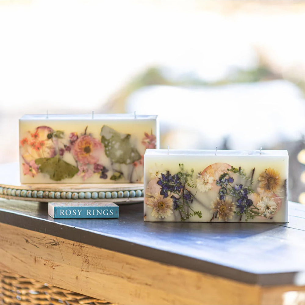 Rosy Rings Blushing Rosewood Brick candle—illuminated glow highlighting hand-placed botanicals for ambiance