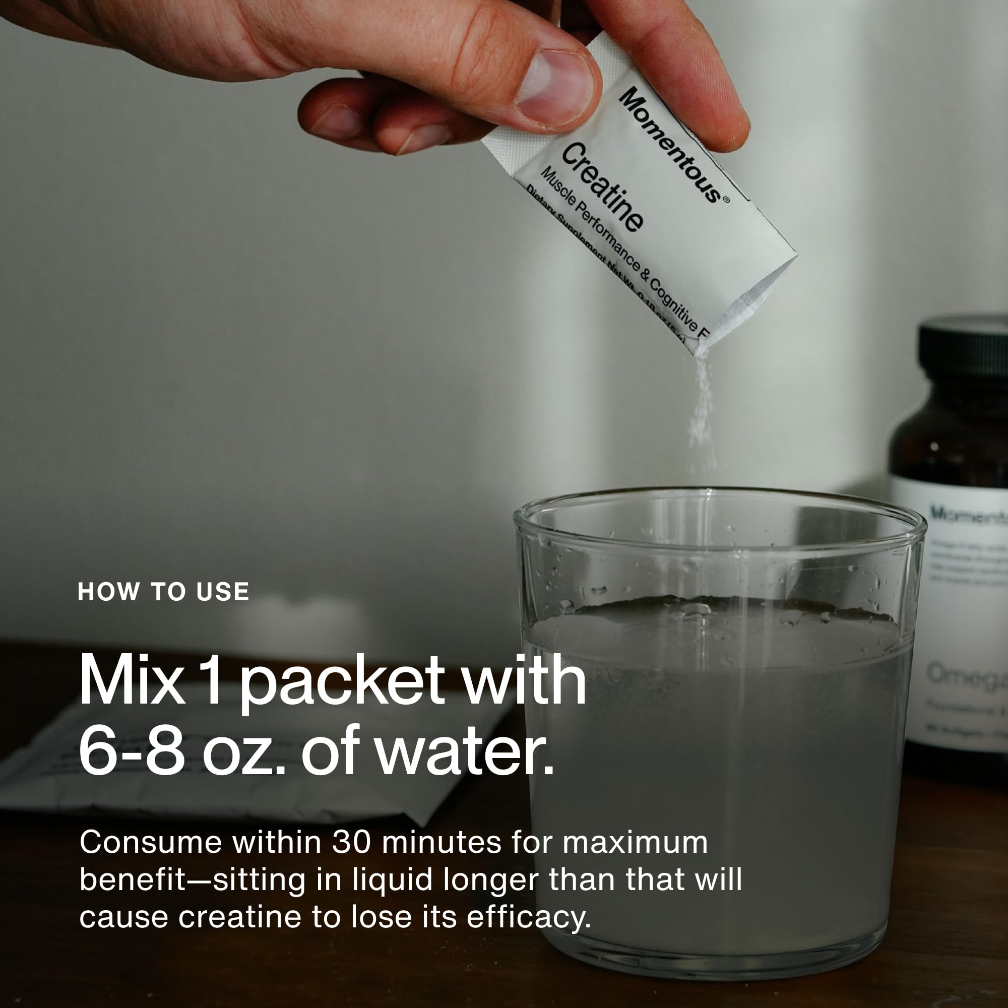 Serving Momentous creatine monohydrate powder in a glass