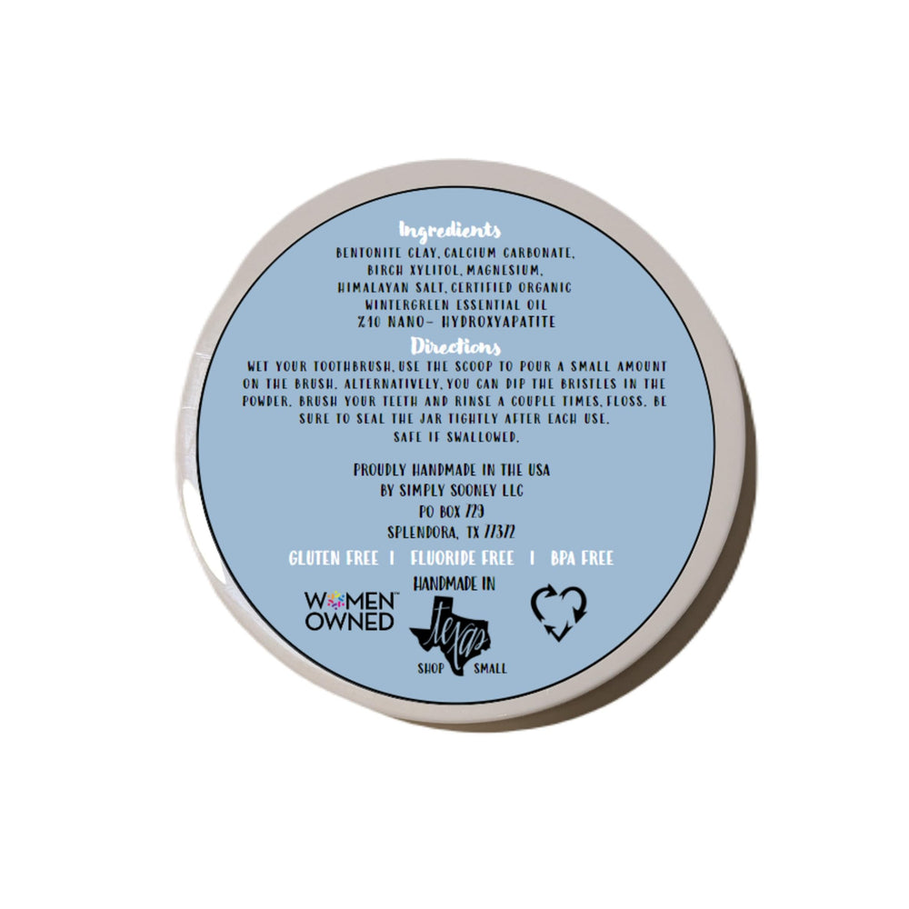 Close-up of Simply Sooney Remineralizing Tooth Powder with a wooden scoop