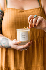 Lifestyle image: orange and clove scented candle in cozy setting