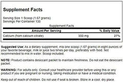 Scooper with calcium citrate powder in a measuring cup