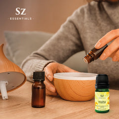 Yuzu essential oil bottle beside citrus slices