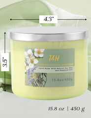 Candle with lid off displaying green glass jar and label