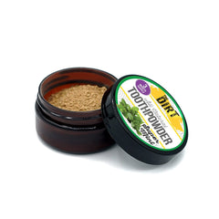 Pouring The Dirt tooth powder onto a damp toothbrush