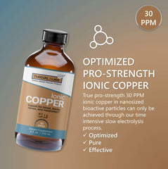 Close-up of glass dropper releasing copper drops