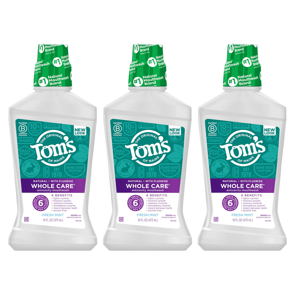 Clear bottle of Fresh Mint mouthwash with mint leaves in background