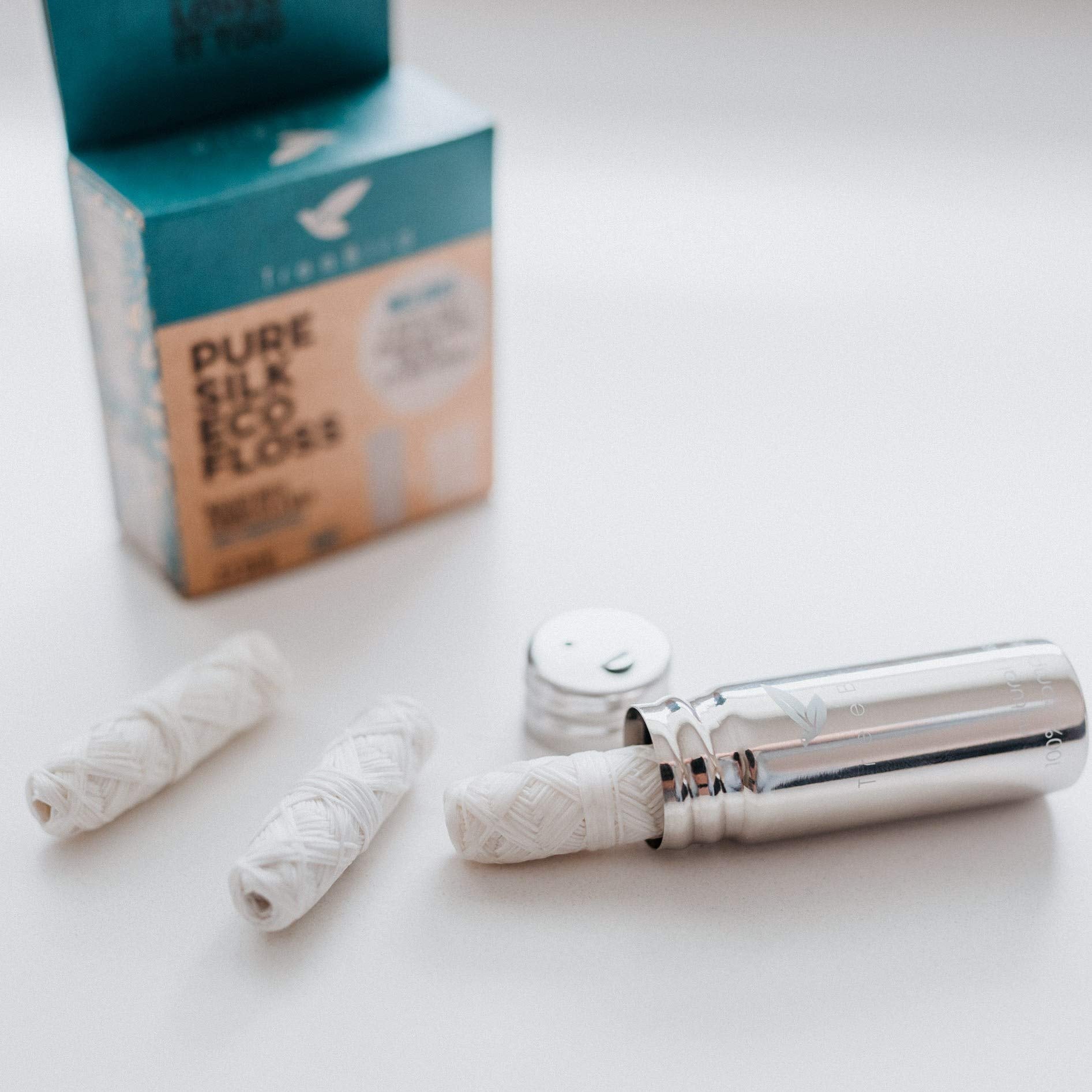 Close-up of silk floss refill spools wrapped in mint wax