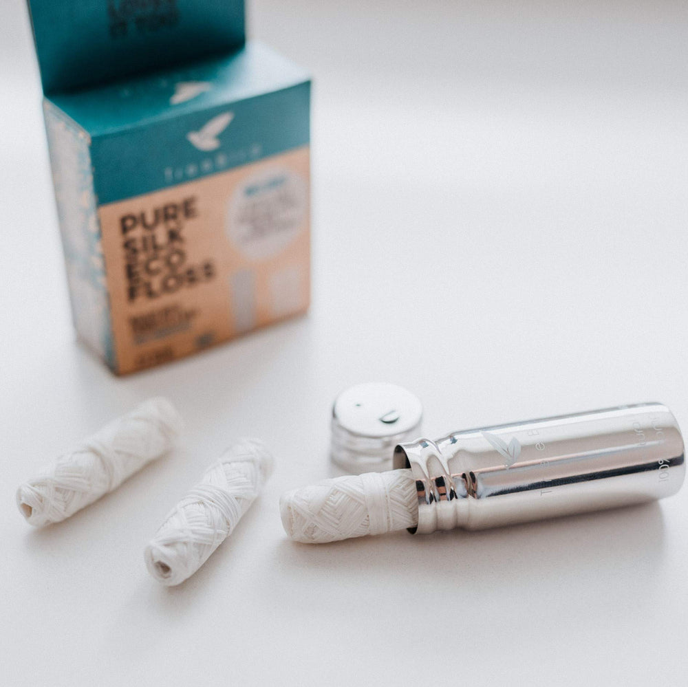 Close-up of silk floss refill spools wrapped in mint wax