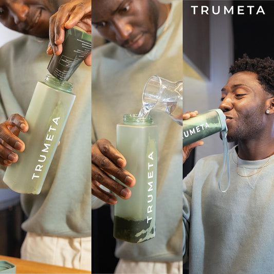 Single travel sachet of TRUMETA greens powder beside a glass of water