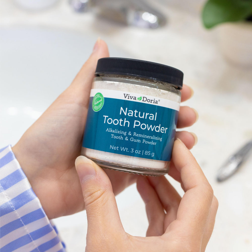 Applying Viva Doria tooth powder to teeth for whitening demo