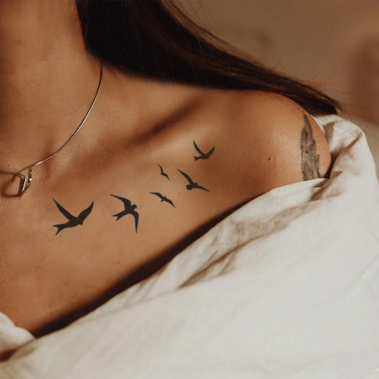WEEKINK bird in flight back tattoo offers versatile placement and an elegant silhouette.