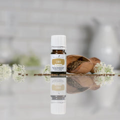 Young Living Cumin Vitality dropper releasing essential oil into a spoon for cooking.