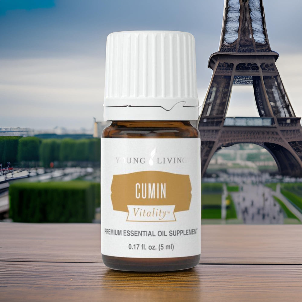 Young Living Cumin Vitality oil poured over roasted vegetables in warm kitchen ambience.