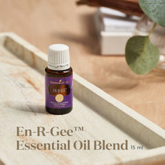 Young Living En-R-Gee bottle with drops beside a diffuser for daytime focus.